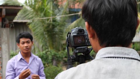 Khmer youth films his friend with DSLR camera on a tripod, youth participation