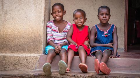 Three Zimbabwean children sitting on a step