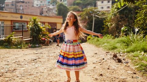 Girl smiles and dances on the streets of Colombia