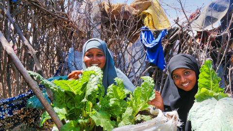 Women with leafy green vegetables