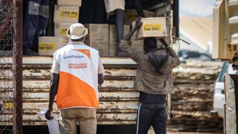 World Vision staff help distribute food