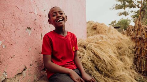 Mensur laughing at the back of his house