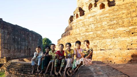 kids sitting on a wall smiling