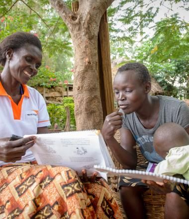 A World Vision Community Health Worker meets with a family in Africa