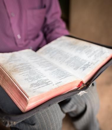 A pastor holds his bible at his church