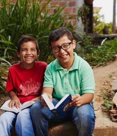 Two Colombian boys reading a book