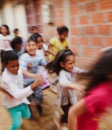 A group of children run in Colombia