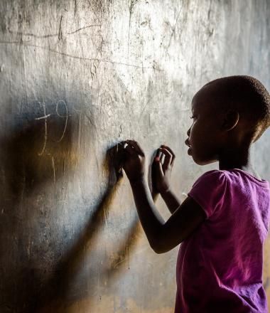 An African girl writes on a Chalkboard