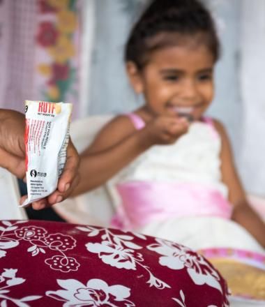 A girl in Latin America eats a food pouch