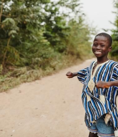 A boy dances on a road in Ghana