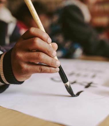 A Chinese boy writes on a paper