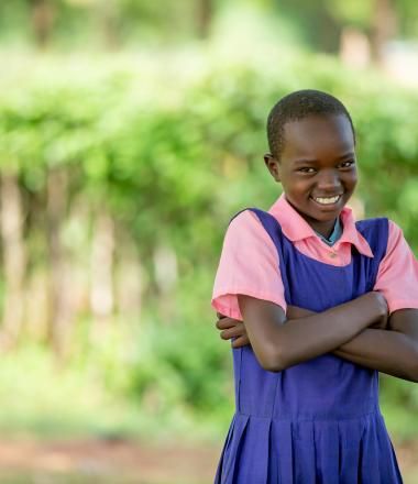 A girl stands in a field in Africa