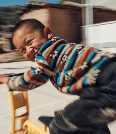 A child in Asia rides a scooter