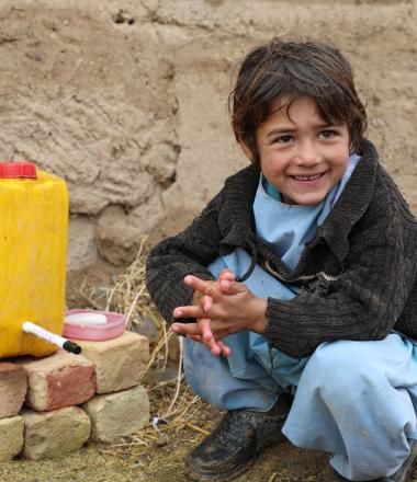 Samiullah is happy to use the water from hand washing station.