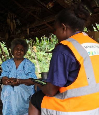 A World Vision enumerator speaking to community member as part of the water, women and disability study