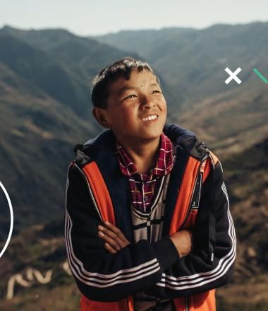 Sponsored child, Chenglong 10 sits with the rolling hills of Wudang in the background.