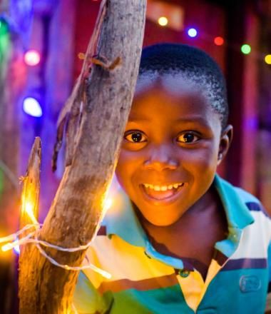 Child in Africa with Christmas lights