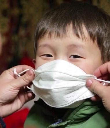How we'll get there, mother puts mask on her child
