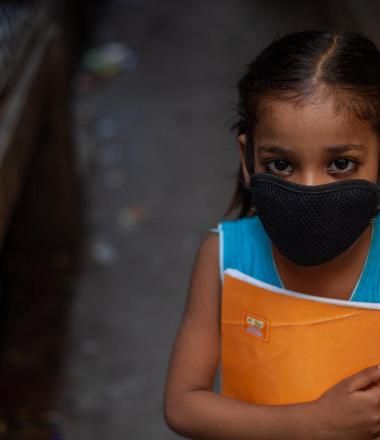 Child in mask with school book in India during COVID-19 Pandemic