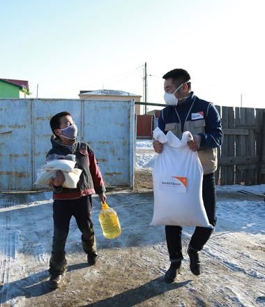 World Vision staff in Mongolia walks with child