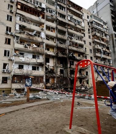 Ukraine bombed buildings and child on a swing