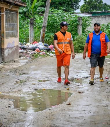 World Vision staff walk down a muddy road