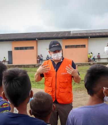 World Vision staff speaks to children