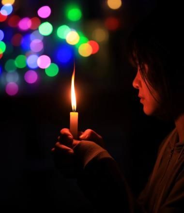 Child holding candle in the dark