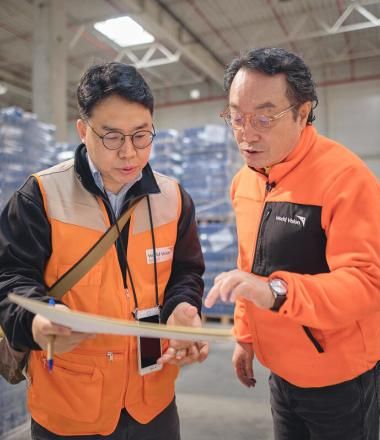 two WVI staff stand in a warehouse talking