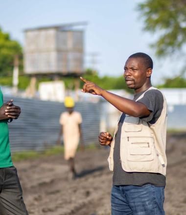 WV staff speaks to FAO staff in a field