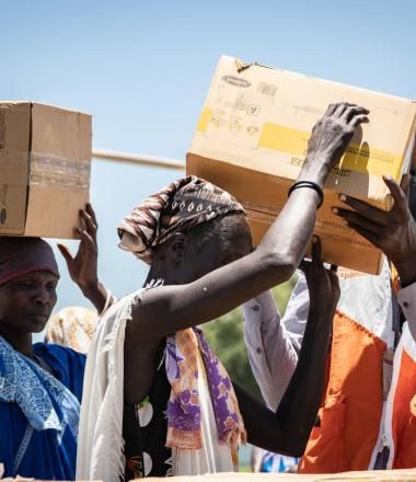 a WV staff member gives boxes of food assistance to women