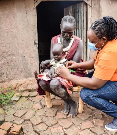 WV staff talks to a woman holding a baby