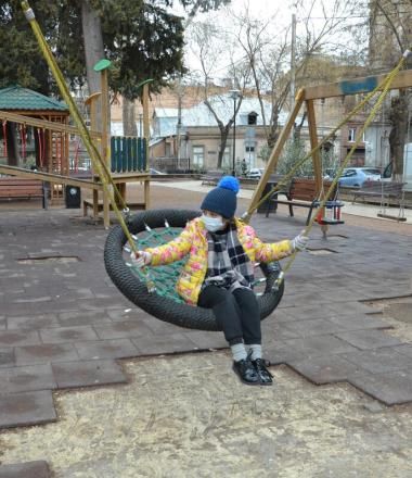 child sits on swing at an empty playground