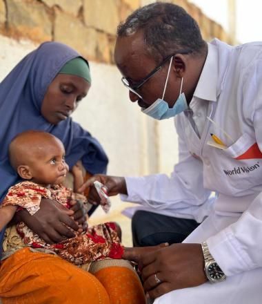 Doctor attends a small baby being held by his mother