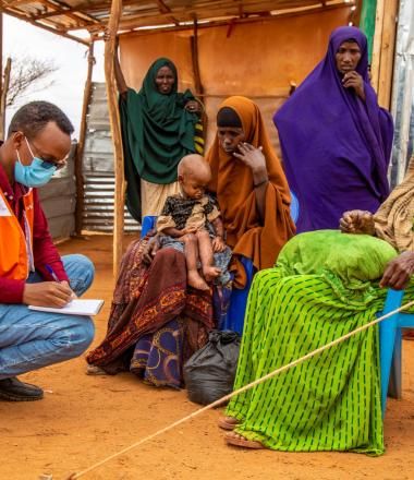 World Vision staff helping a sick child in a community