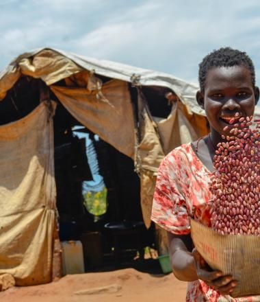 Woman in refugee camp with grain 