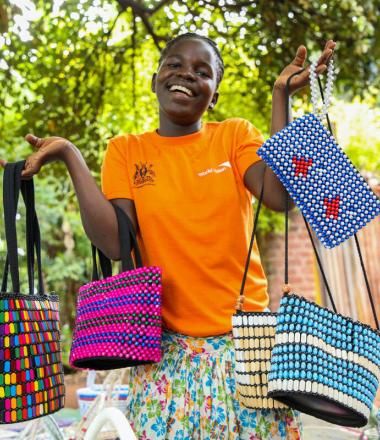 Young girl in orange shirt shows colorful bags