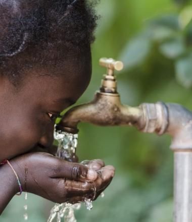 Girl drinking from a tap