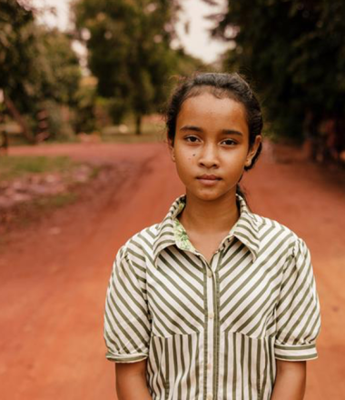 girl standing on red dirt road