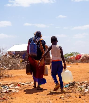 Two people carrying their belongings in the drought-ridden portions of Somalia