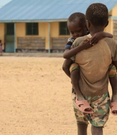 Young boy carries his brother