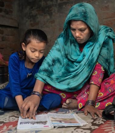 A mother teaches her daughter in Sarlahi.