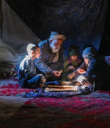 A father feeding his children in Afghanistan