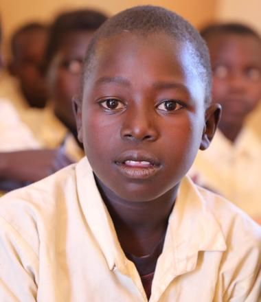 A child sitting in class with his friends