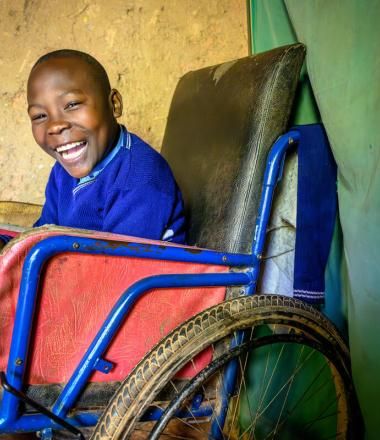 Abraham smiling as he its in his wheelchair