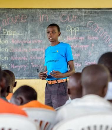 Children listen to John Bosco Mugagga, a World Vision Child Protection and Advocacy Officer, during a Child Parliament meeting at a school in Nakasongola, Uganda