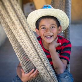 Boy in hat sitting in hammock