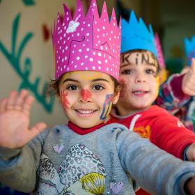 Children with face paint wearing crowns