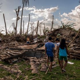 A family in the Philippines surveys the devastation of Typhoon Haiyan