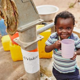 A boy in Ghana drinks water from a World Vision well. 